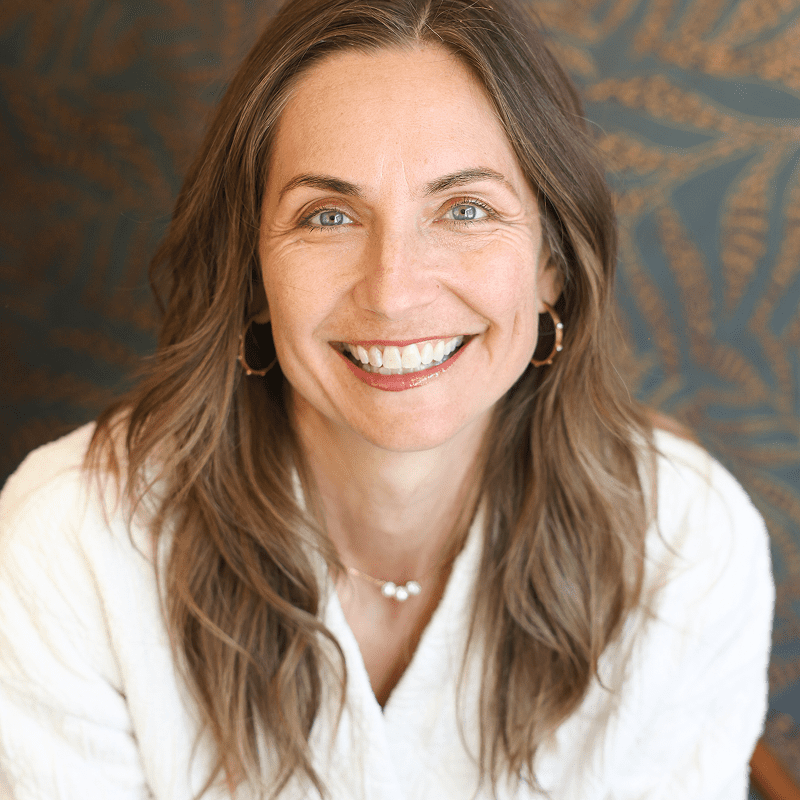 Smiling woman with long hair and earrings.